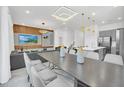 Bright dining room features a large table with seating for eight and modern lighting fixtures at 6115 High Seas Dr, Orlando, FL 32821