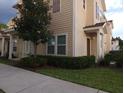Two-story townhome with light beige exterior and dark brown door at 8947 Shine Dr, Kissimmee, FL 34747