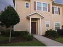 Two-story townhome with light beige exterior and dark brown door at 8947 Shine Dr, Kissimmee, FL 34747