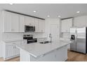 Modern kitchen with white cabinets, stainless steel appliances, and an island at 3606 Walking Stick Way, Poinciana, FL 34759