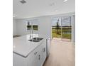 Bright kitchen with white cabinets, an island, and sliding doors leading to a patio at 3606 Walking Stick Way, Poinciana, FL 34759