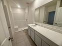 Clean and modern bathroom with shower, white vanity, and large mirror at 2010 Canton Park Dr, Winter Haven, FL 33881