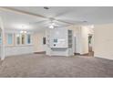 Spacious living room with neutral carpeting and built-in shelving at 538 Saint Andrews Blvd, The Villages, FL 32159