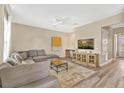 Open living room with gray sectional sofa and large TV at 7768 Linkside Loop, Reunion, FL 34747