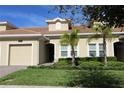 Tan two-story townhome with a two-car garage at 1165 Trappers Trail Loop, Davenport, FL 33896