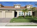Tan two-story townhome with a two-car garage at 1165 Trappers Trail Loop, Davenport, FL 33896