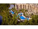 Aerial view of resort with multiple pools, landscaping, and a lake at 14501 Grove Resort Ave # 1105, Winter Garden, FL 34787