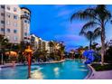 Evening view of resort pool with water features, palm trees, and building in background at 14501 Grove Resort Ave # 1105, Winter Garden, FL 34787