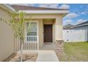 House entrance with a brown door and white railing at 665 Persian Dr, Haines City, FL 33844