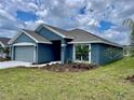 Gray house with a two-car garage and well-maintained lawn at 530 Tanaro Ln, Haines City, FL 33844