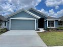 One-story home with gray exterior, two-car garage, and landscaped lawn at 530 Tanaro Ln, Haines City, FL 33844