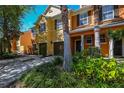 Two story townhome with orange and beige exterior, two car garage, and lush landscaping at 868 Assembly Ct, Reunion, FL 34747