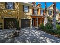 Front view of townhome with two car garage, landscaping, and walkway at 868 Assembly Ct, Reunion, FL 34747