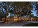 Evening view of home with stone exterior, landscaping, and driveway at 208 Green Lake Cir, Longwood, FL 32779