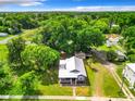 Aerial view of gray house with large yard and trees at 1826 W Silver Springs Blvd, Ocala, FL 34475