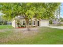 One-story house with a two-car garage and a large tree in the front yard at 927 Cambridge Ct, Kissimmee, FL 34758