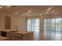 Open concept kitchen and living area with tile flooring and sliding doors at 204 Barrington Dr, Haines City, FL 33844