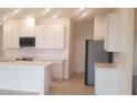 Bright kitchen with white cabinets, stainless steel appliances, and an island at 204 Barrington Dr, Haines City, FL 33844