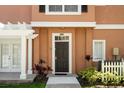 Townhouse front entrance with a dark brown door and landscaping at 2208 San Vittorino Cir # 101, Kissimmee, FL 34741