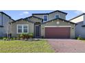 Two-story house with a red door and brick driveway at 5692 Camilla St, St Cloud, FL 34771