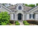 Front entrance of a home with a gray exterior and black door at 310 Vista Oak Dr, Longwood, FL 32779