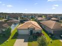 One-story house with a brown tile roof, in a community of similar homes at 196 Aidans Lndg, Haines City, FL 33844