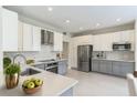 Modern kitchen with gray and white cabinets, stainless steel appliances, and quartz countertops at 2111 Turnberry Dr, Oviedo, FL 32765