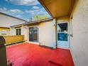 Private patio with red tile flooring, sliding glass door access, and small planted area at 254 Windmeadows St # 254, Altamonte Springs, FL 32701