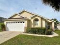 House exterior featuring a white garage door and landscaping at 2555 Oneida Loop, Kissimmee, FL 34747