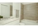 Bathroom with a bathtub, granite countertop, and neutral tile at 1740 Pacific Rd, Kissimmee, FL 34759