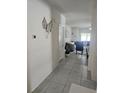 Bright entryway with tile flooring, leading to living room with gray sofa and blue chairs at 66 Orchid Ct, Kissimmee, FL 34759