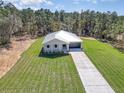 Single story house, driveway, and grassy yard near treeline at 12636 Sw 62Nd Pl, Ocala, FL 34481