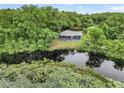 House nestled on a waterfront lot, lush trees surround the property at 10 Locust Run Crse, Ocala, FL 34472