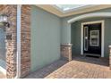 Front entry with brick columns, dark door, and a paved walkway at 230 Minton Loop, Kissimmee, FL 34747
