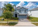 Two-story home with gray exterior and a two-car garage at 8831 Interlocking Ct, Davenport, FL 33896