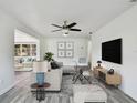 Bright living room with hardwood floors and a large TV at 1009 Loves Point Dr, Leesburg, FL 34748
