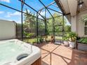 Hot tub in screened enclosure with lush landscaping at 4904 W Fountainwood Dr, St Cloud, FL 34772