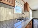 Modern kitchen sink with granite countertop and a window overlooking the backyard at 40407 Sunset Dr, Eustis, FL 32736