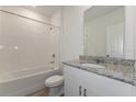 Clean bathroom with granite countertop, white cabinets, and bathtub at 1167 Foreshore Ln, Haines City, FL 33844