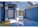 Exterior view of a light blue house with a white door and walkway at 1112 Royal Marquis Cir, Ocoee, FL 34761