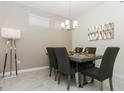 Bright dining room with a modern table and chairs, stylish light fixture, and wall art at 4731 Clock Tower Dr # 101, Kissimmee, FL 34746