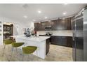 Modern kitchen with dark cabinetry, quartz countertops, and an island at 875 Fillmore Ct, Davenport, FL 33837