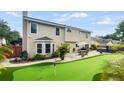 Large backyard with putting green, patio, hot tub, and tropical landscaping at 4436 Yachtmans Ct, Orlando, FL 32812