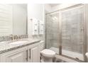 Clean bathroom with shower, toilet and granite vanity at 1136 Castle Pines Ct, Reunion, FL 34747