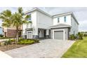 Modern two-story home with gray stone and two garages at 1136 Castle Pines Ct, Reunion, FL 34747