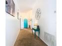 Bright hallway with teal accent table and a teal door at 114 Castlemain Cir, Davenport, FL 33897