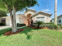One-story house with a lush green lawn and mature trees at 114 Castlemain Cir, Davenport, FL 33897