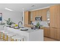 Modern kitchen with light wood cabinets and a large island at 6406 Chorus Dr, Mascotte, FL 34753
