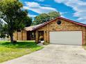 Brick house with a two-car garage and solar panels on the roof at 2037 Apricot Dr, Deltona, FL 32725