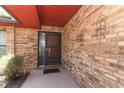 Brick front porch with a brown door and black screen at 2037 Apricot Dr, Deltona, FL 32725